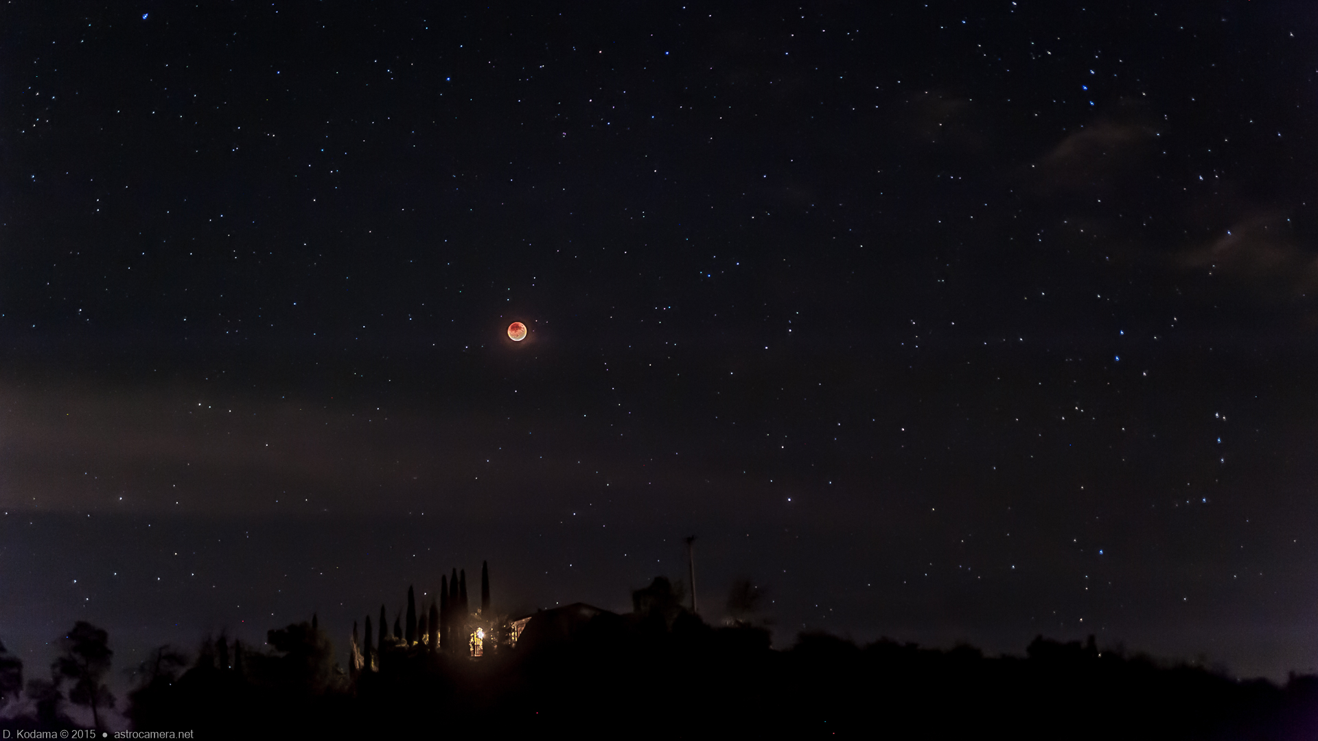 Eclipsed moon over neighbor's house